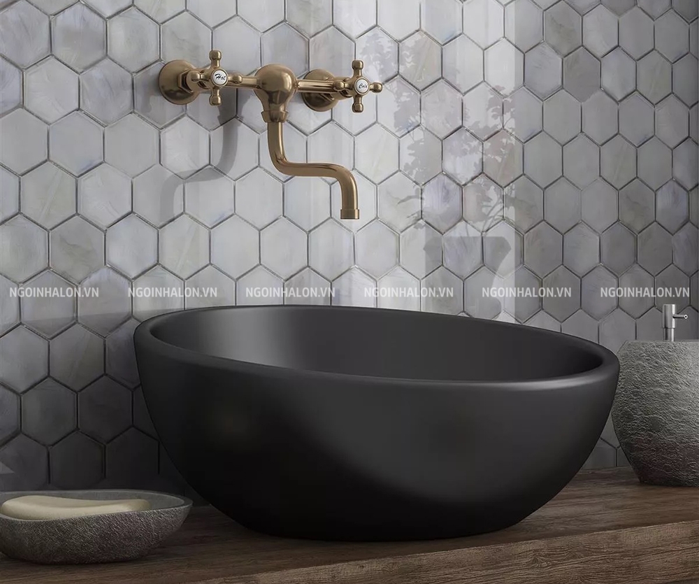 Bề mặt men bóng phản chiếu ánh sáng, làm nổi bật từng viên gạch lục giác xám trong phòng tắm.